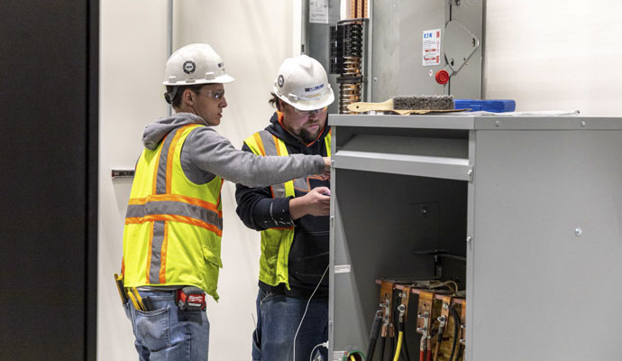 An M.C. Dean technician and an apprentice work together in a customer facility.